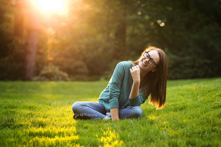 Senior girl laughing sitting in the grass. Midland, Michigan photographer