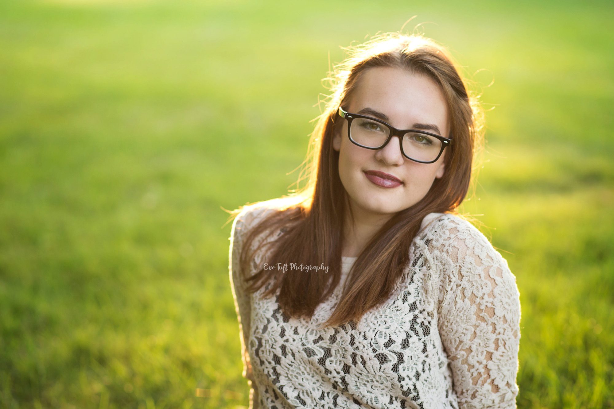 Senior girl softly smiling in the grass. Midland, Michigan photographer