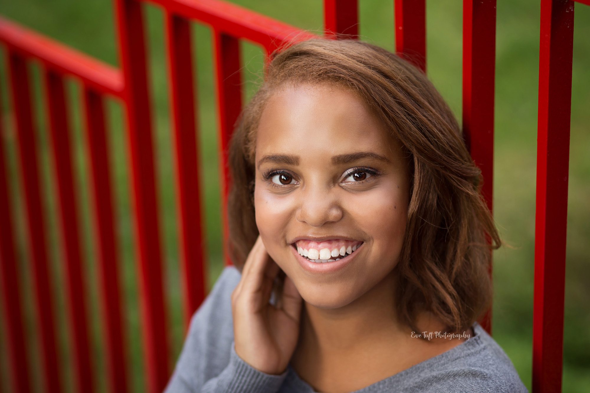 Senior girl sitting on a red bridge at Dow Gardens. Midland, Michigan Photographer