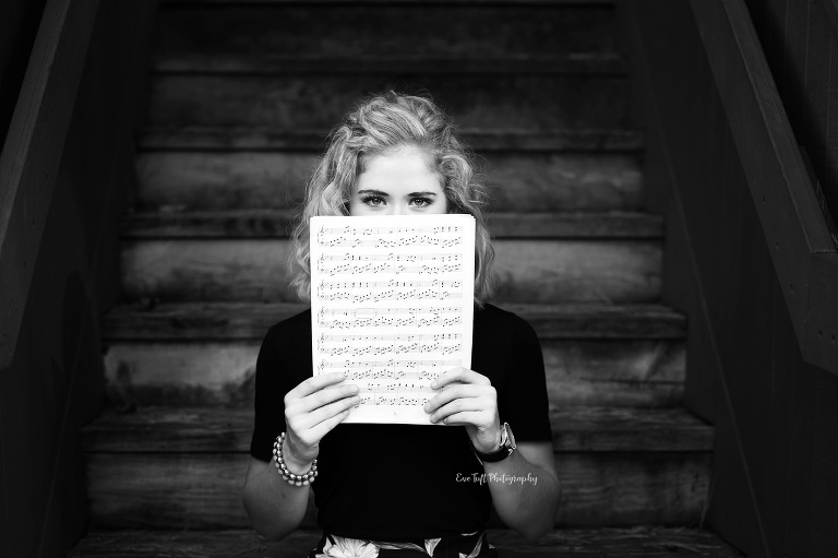 Senior girl holding up sheet music in black and white. Midland, Michigan photographer