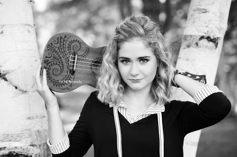 Senior girl holding her ukulele on her shoulders in black and white. Midland, Michigan photographer