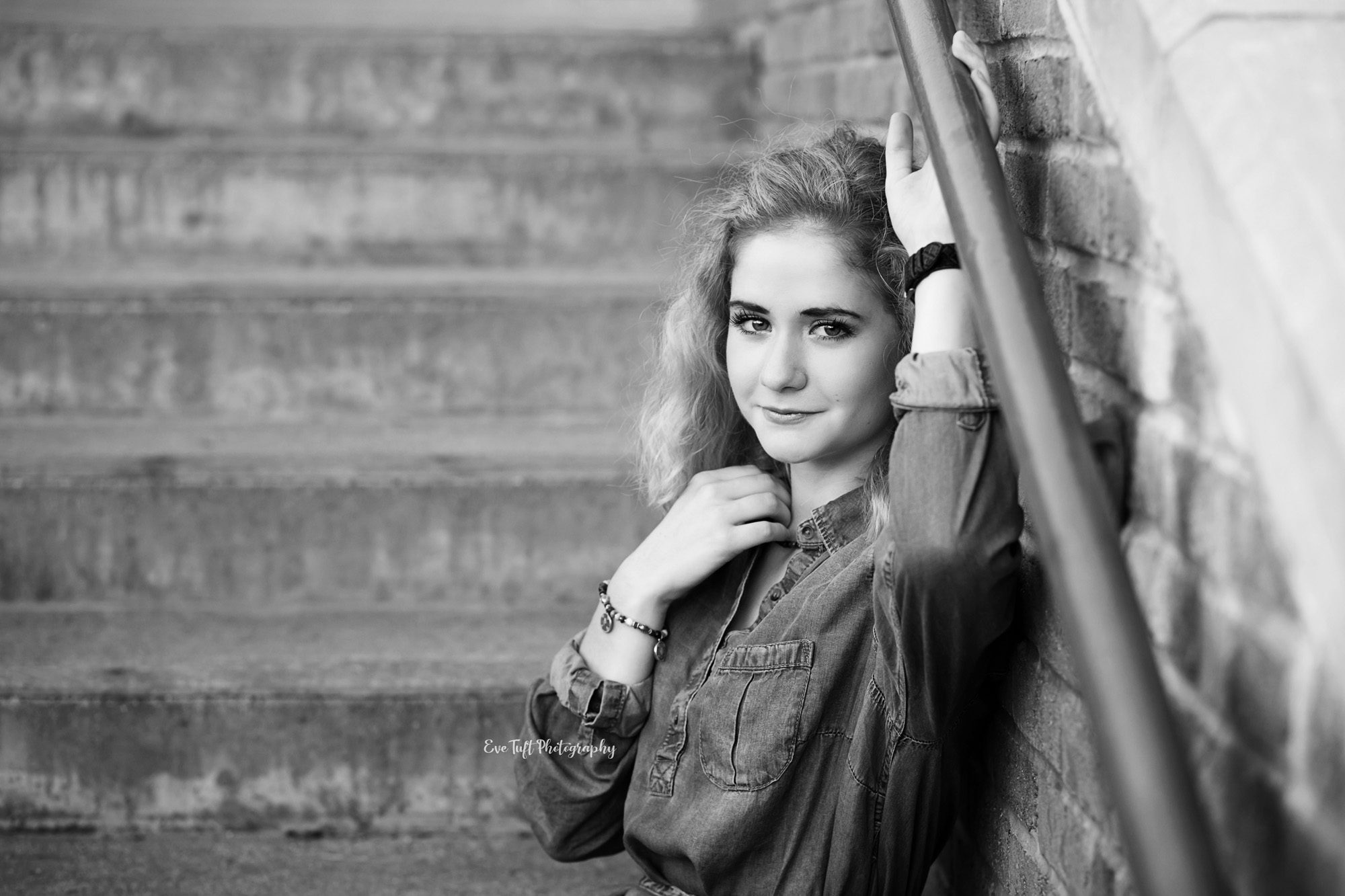 Senior girl on stairs holding onto rail in black and white. Midland, Michigan photographer