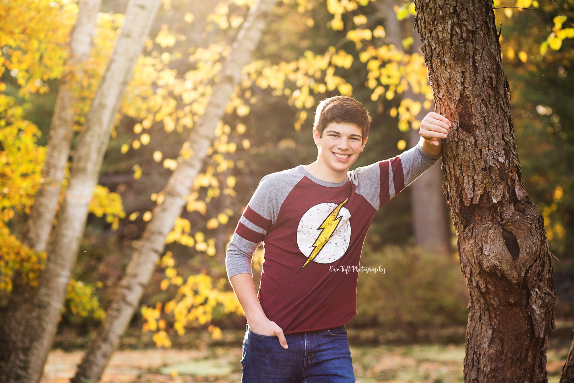 Senior boy outside leaning up against a tree at Dow Gardens. Midland, Michigan photographer