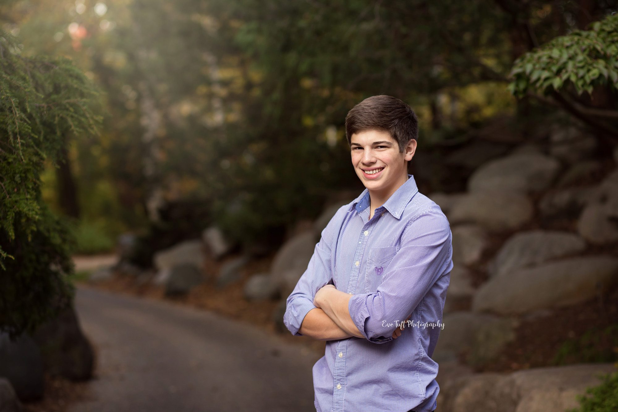 Senior wearing purple shirt at Dow Gardens with arms folded across his chest. Midland, Michigan photographer