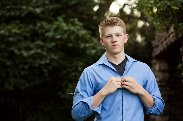 Senior boy unbuttoning his blue shirt. Midland, Michigan photographer