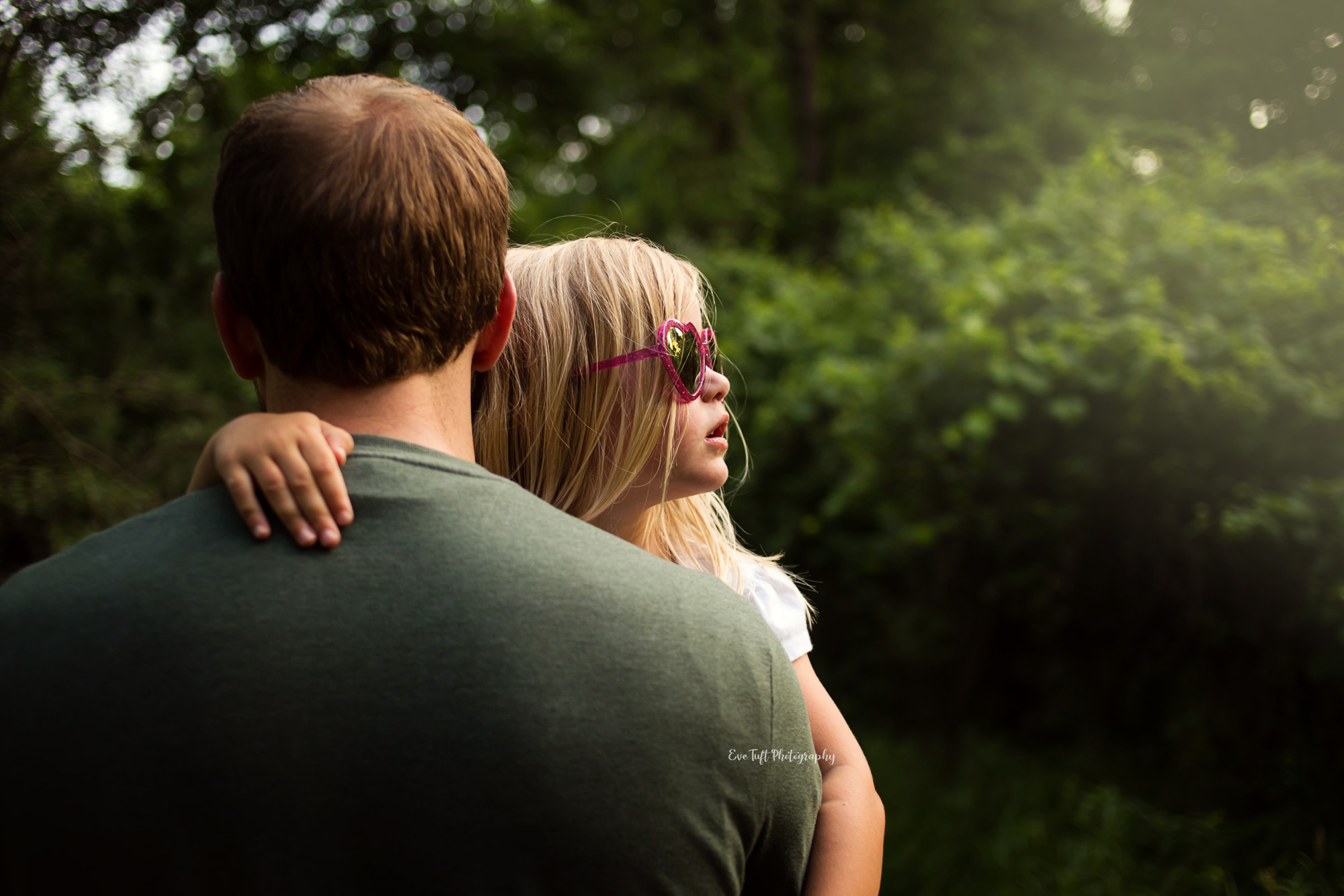 Small girl wearing sunglasses being held by her dad while out for a walk. Midland, Michigan photographer