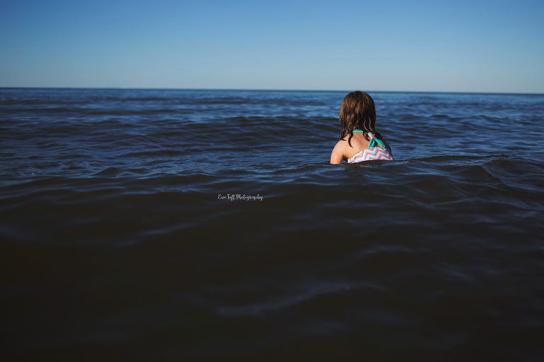 Girl floating in a large lake. Midland Michigan photographer