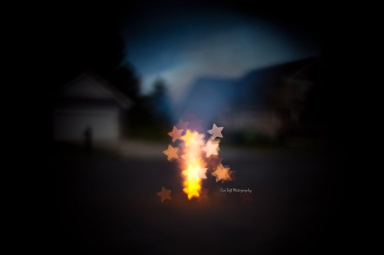 Star shaped bokeh fireworks in front of a house on the fourth of July. Midland, Michigan photographer