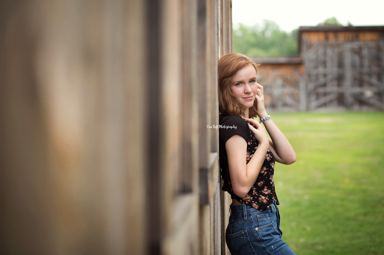Senior girl leaning against an old barn in Midland, MI