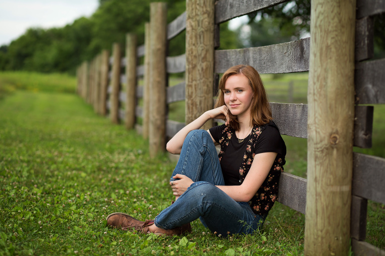 Senior girl posing by a wooden fence. Midland, MI photographer