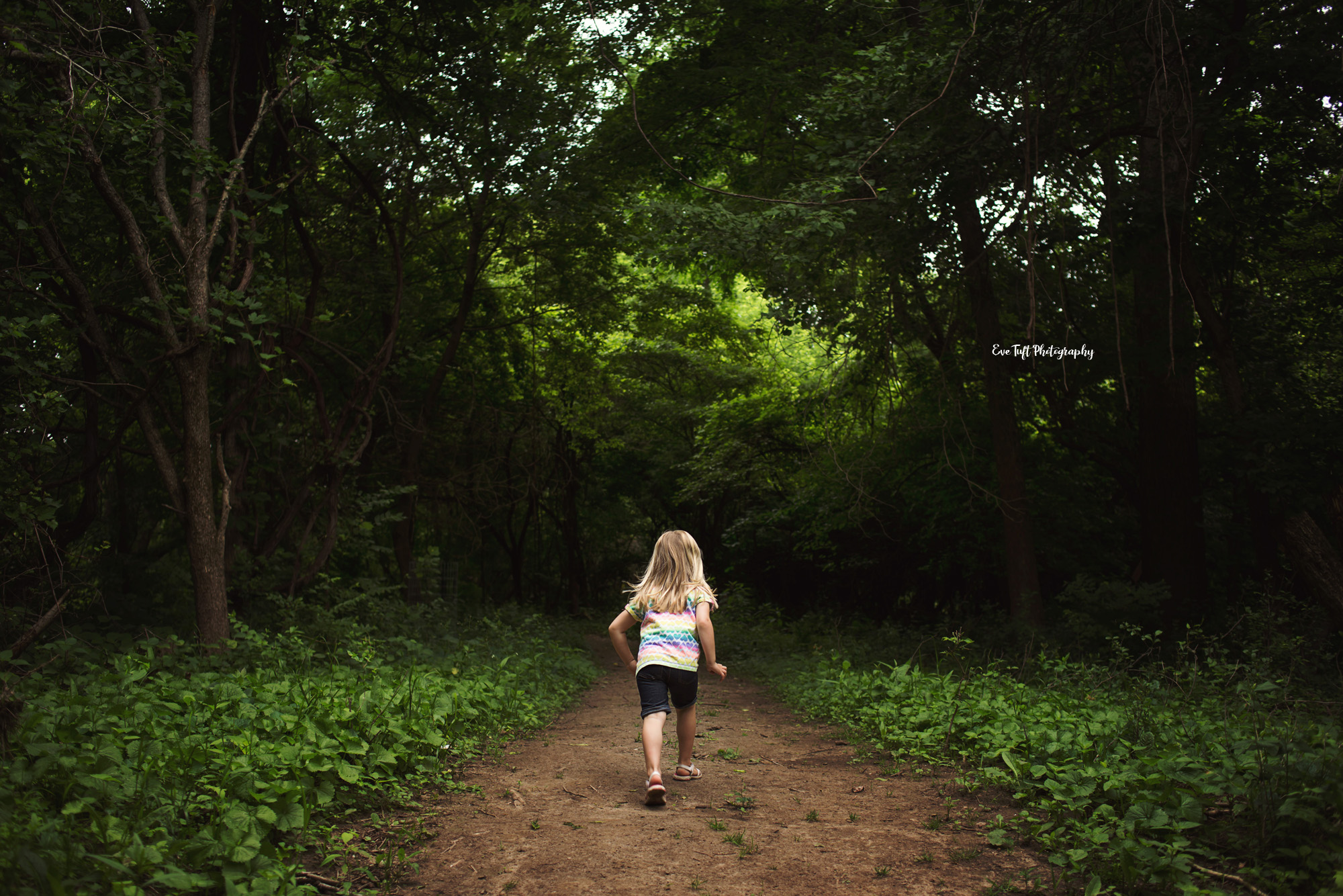 Little girl running into the woods at the Chippewa Nature Center. Midland Photographer