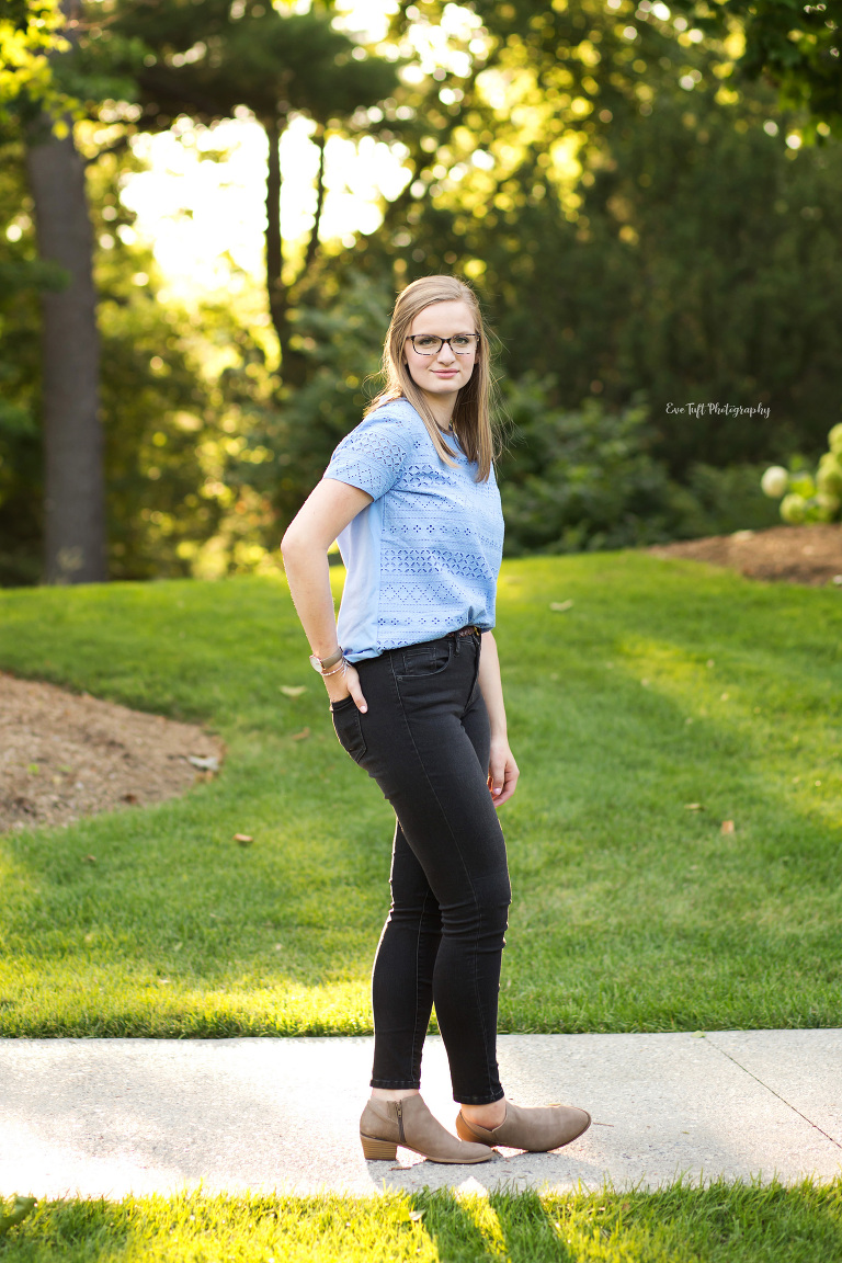 High school senior girl posing in front of trees and grass. Saginaw Photographer