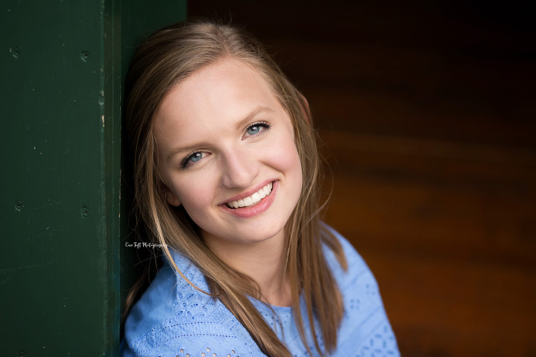 Close up of a gorgeous senior girl next to a green barn door. Bay City Photographer