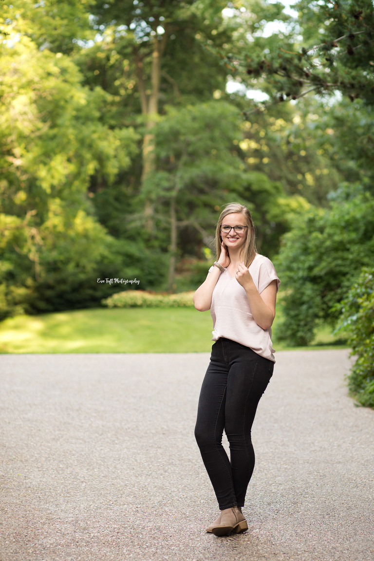 Senior girl standing in front of trees and grass. Michigan Photographer