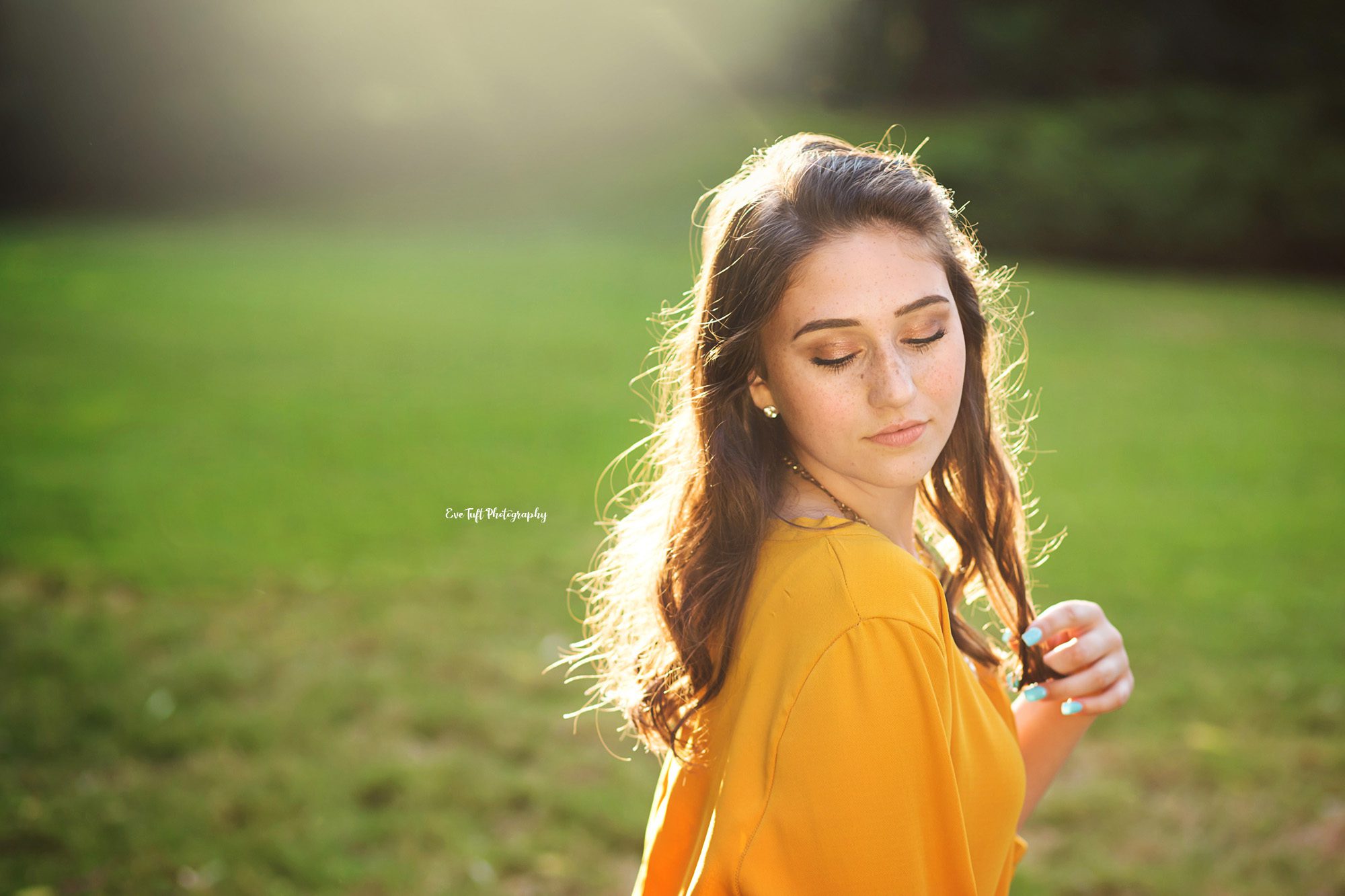 Senior girl in a yellow dress looking down at the ground | Bay City Portraits