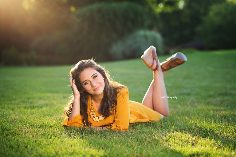 Senior girl lying in the grass on a hill | Dow Gardens pictures