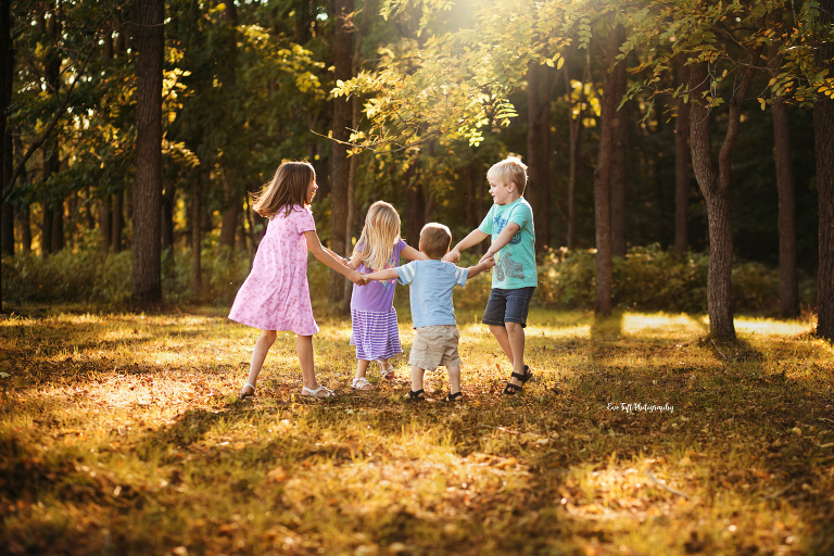 Four siblings playing in the fall leaves in September | Midland Photographer