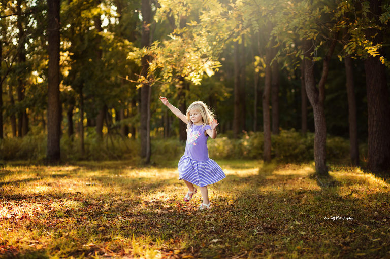 A little girl twirling outside in the leaves | Saginaw photography