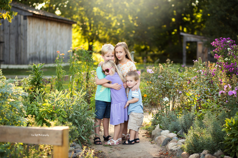 Four siblings hugging each other outside in a garden | Michigan Portrait Photographer