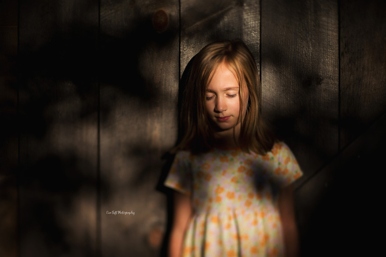 A little girl standing in front of a barn in dappled light | Saginaw, MI photographer