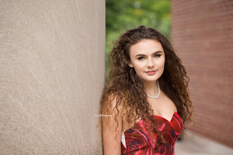 Portrait of a senior girl in a formal dress who has a pearl necklace and long, wavy hair | Michigan photographer