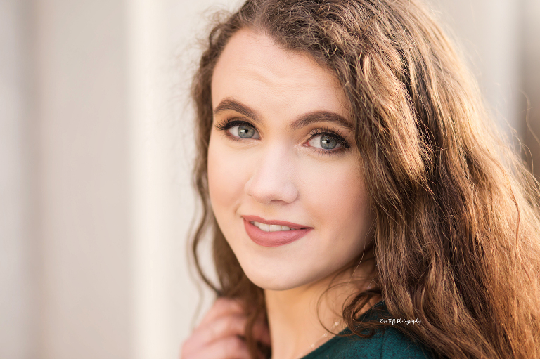 Close up of a senior girl with brown hair with her hand in her hair | Michigan Portrait Photographer