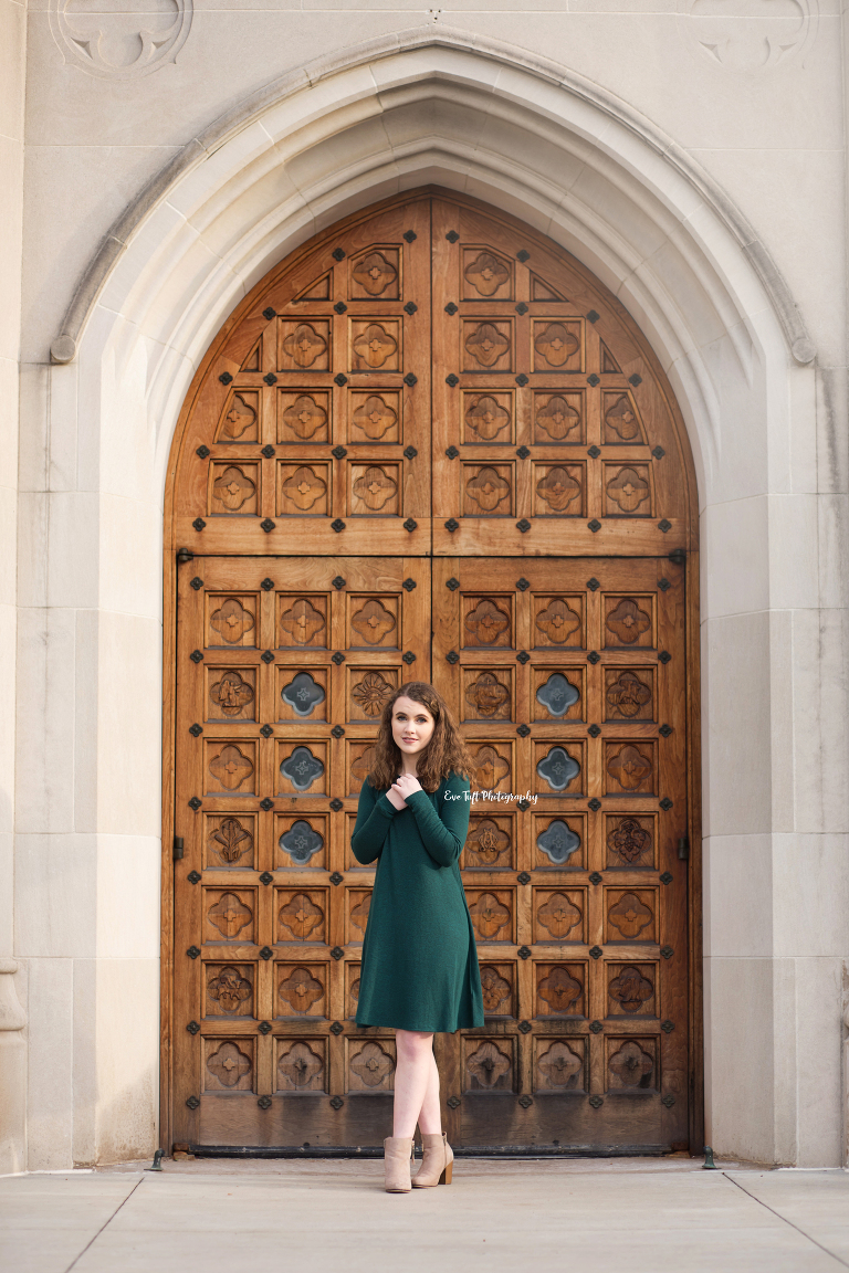Senior girl standing in front of some church doors in downtown Midland, Michigan