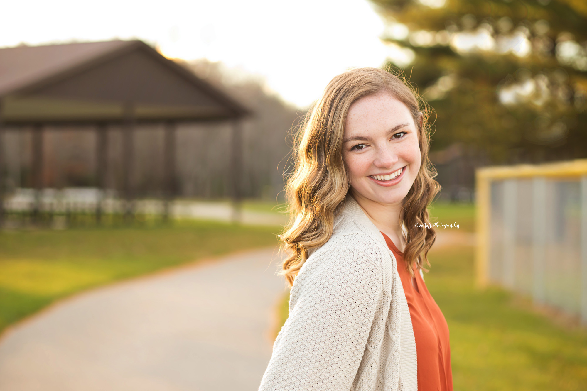 Senior girl smiling while looking over her shoulder | High School Senior Pictures