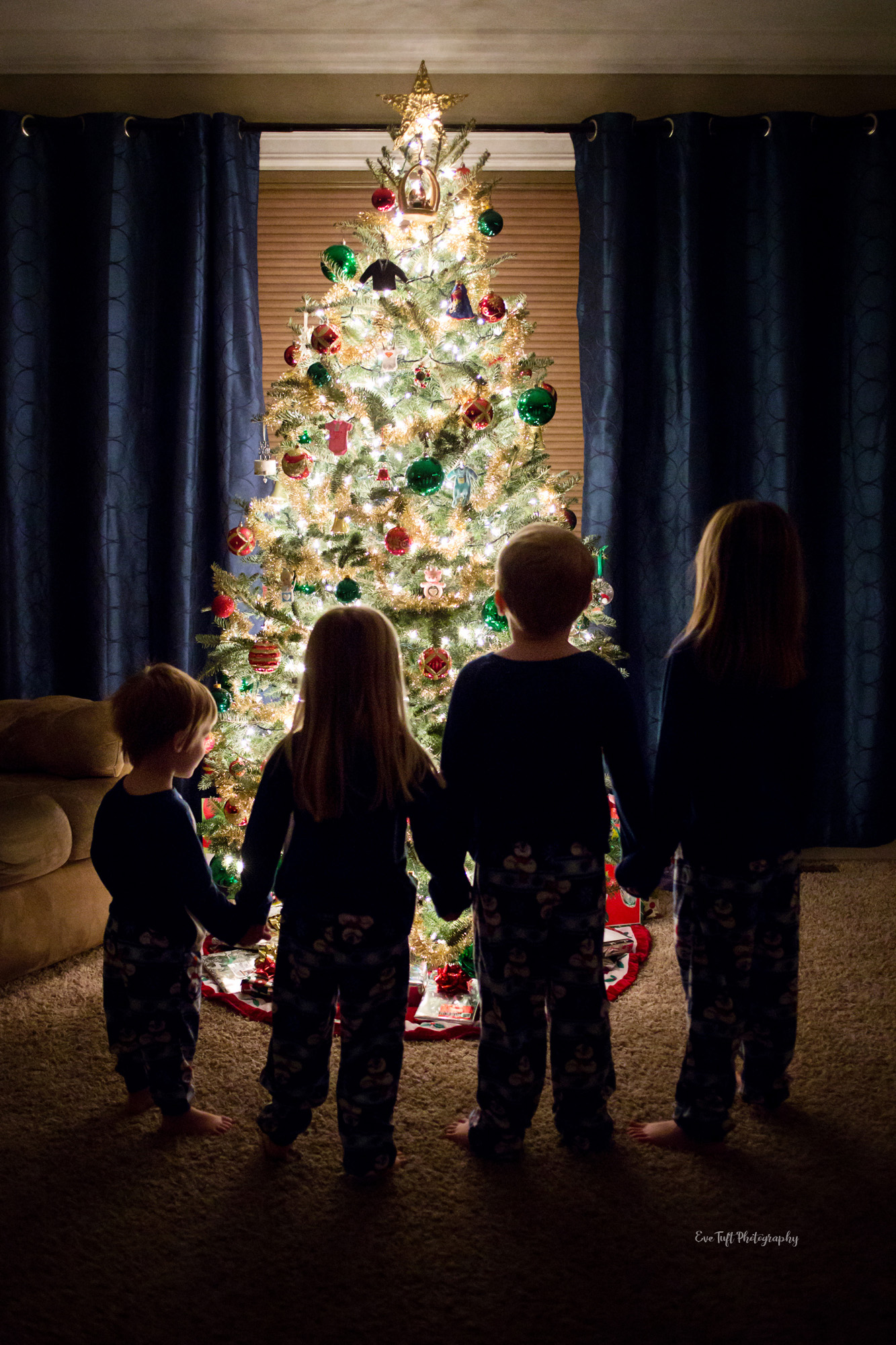 Four Children holding hands around the Christmas tree in their home | Eve Tuft, Midland Senior Photographer
