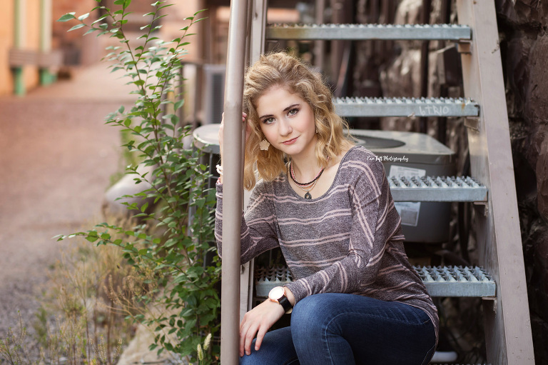 A high school senior girl sitting on some stairs in an alley downtown in Midland, Michigan | Portrait Photographer