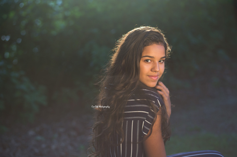 Senior girl touching her hair while smiling at the camera | High School Senior Photographer