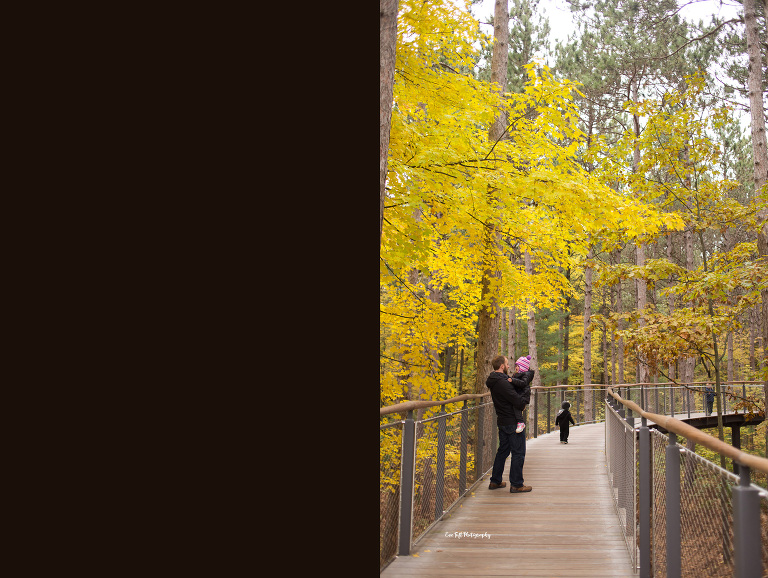 Father holding his daughter outside in the fall on a pathway | Senior Portrait Photographer in Midland, Michigan