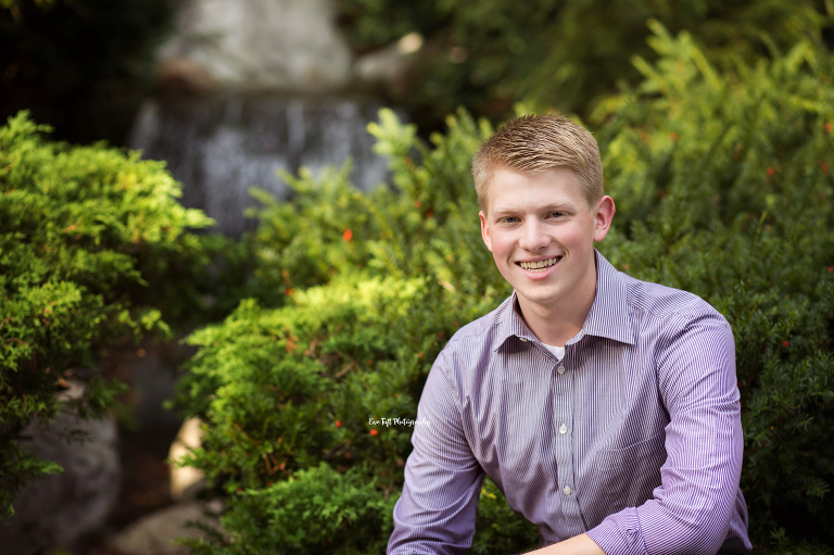 Senior photography session for a boy sitting in front of a waterfall | Midland, Michigan Photographer