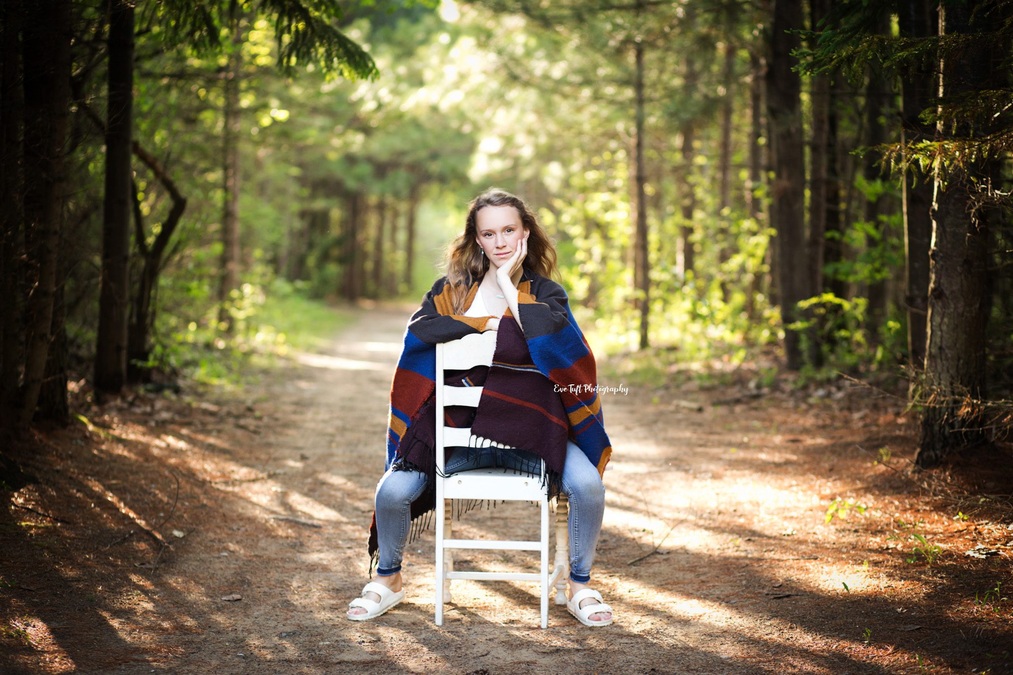 Senior gil sitting backwards on a chair outside in City Forest, Midland, Michigan