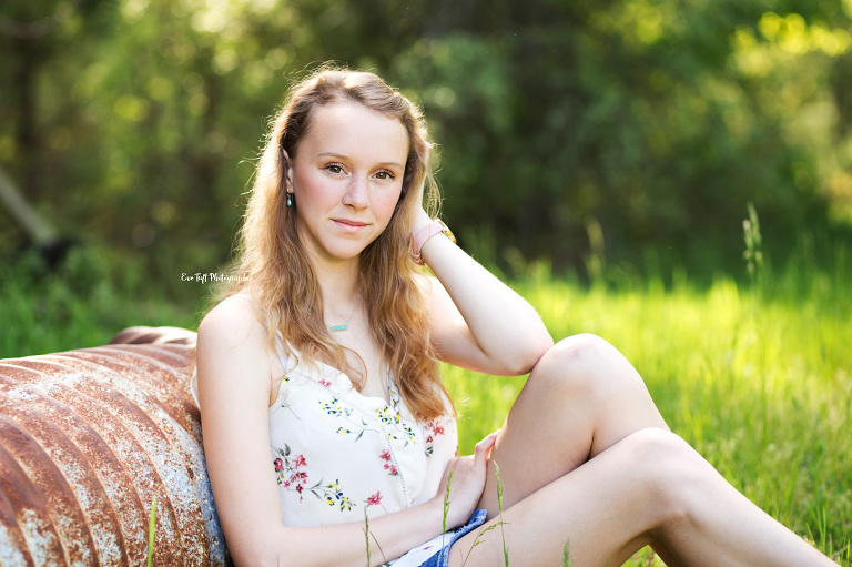 The first senior of the year for Eve Tuft Photography | Senior girl sitting in the grass and resting her head on her hand