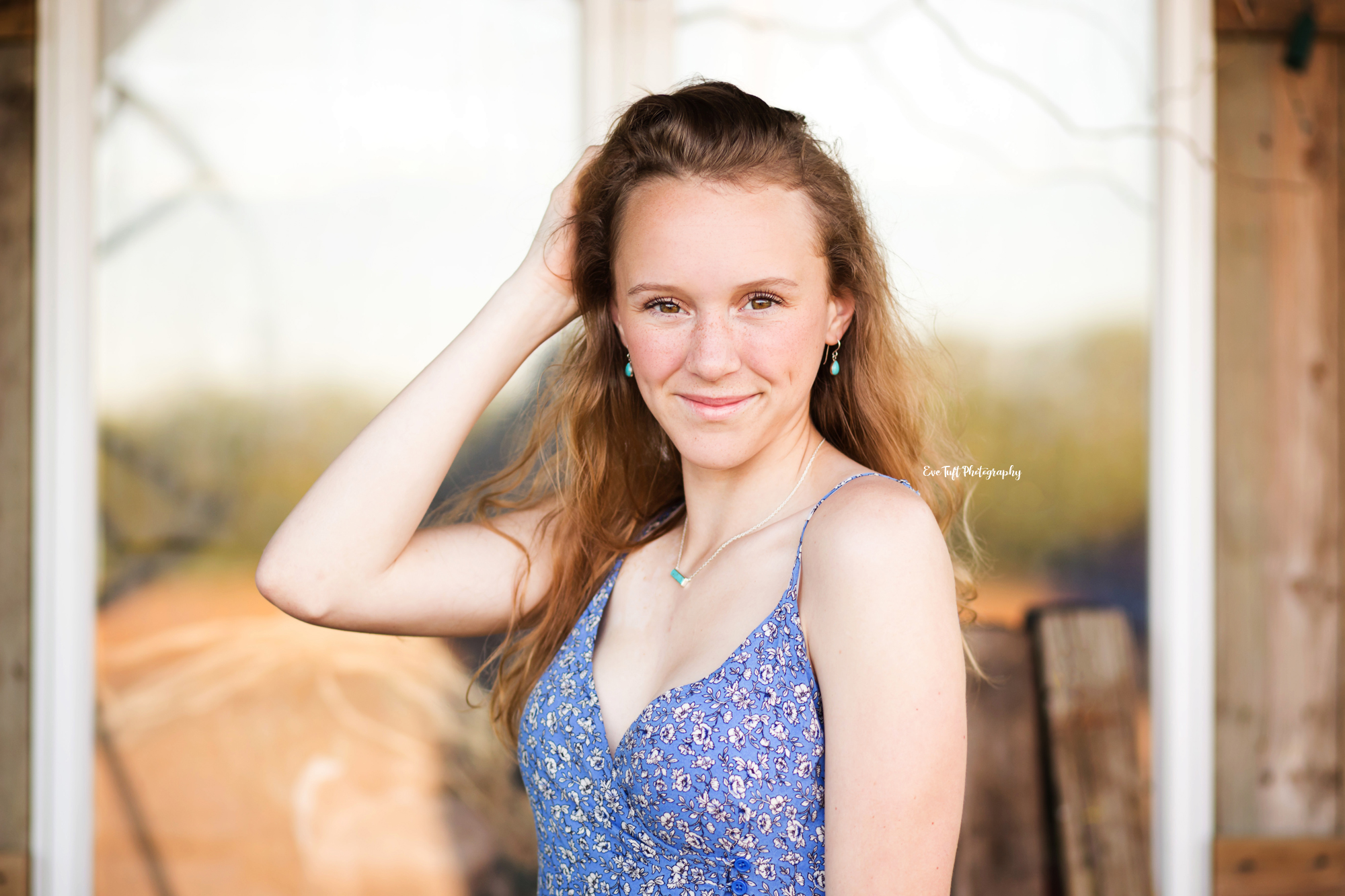 Senior girl posing in front of a window with her hand in her hair | Midland, Michigan Senior Portrait Photographer