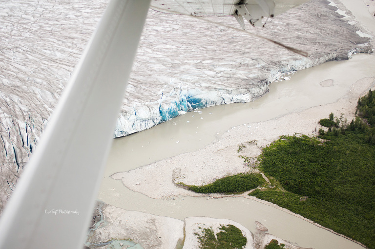 Blue and white glaciers seen outside a plane window