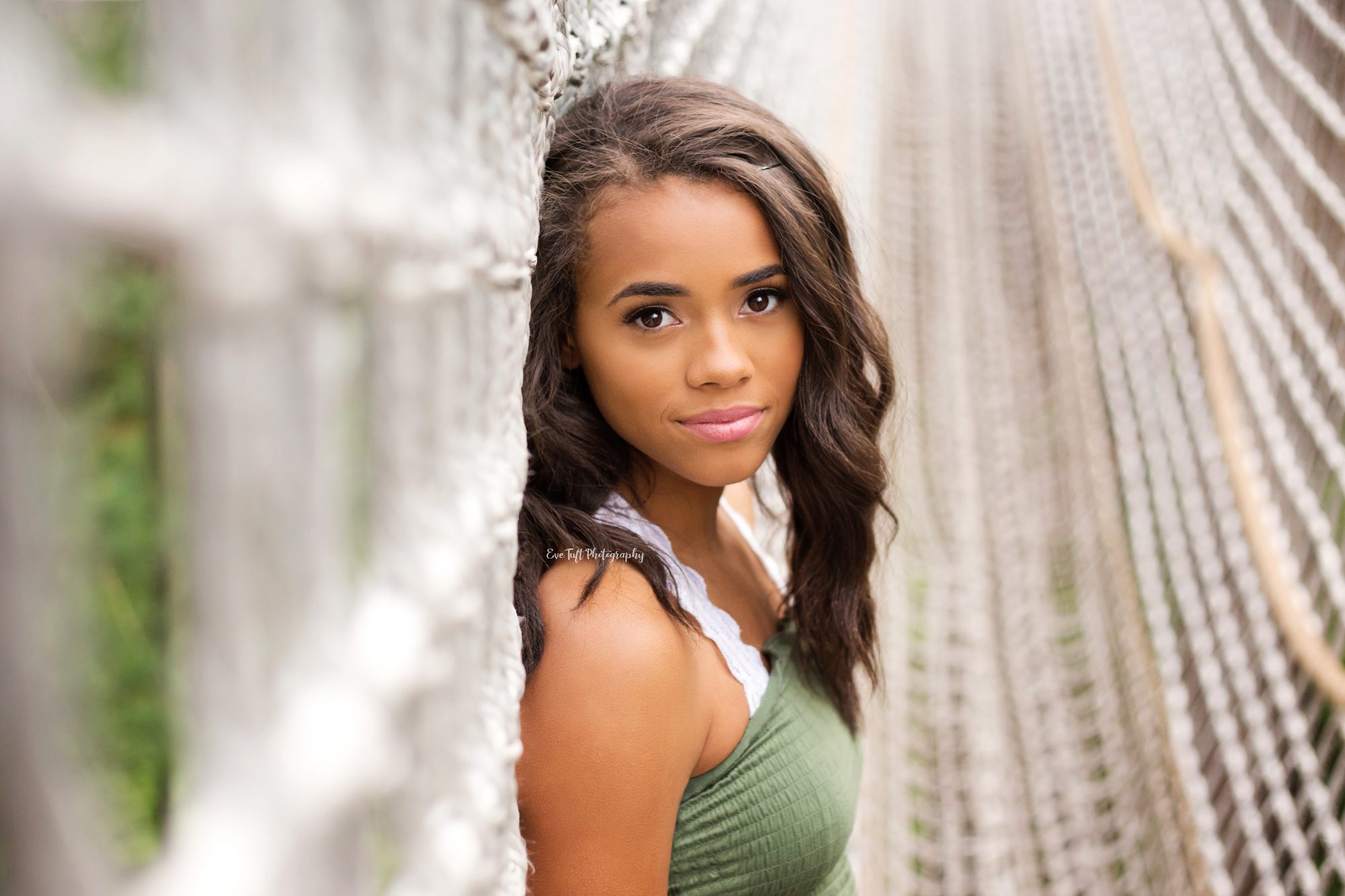 Senior girl looking at the camera while on a rope bridge | Saginaw Photographer