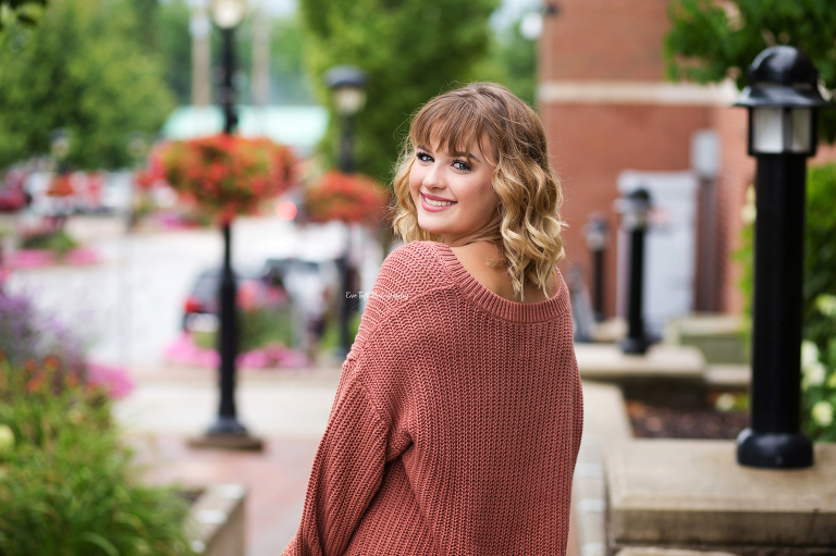 Senior girl looking over her shoulder and smiling at the camera | Senior Photographer in Midland, Michigan