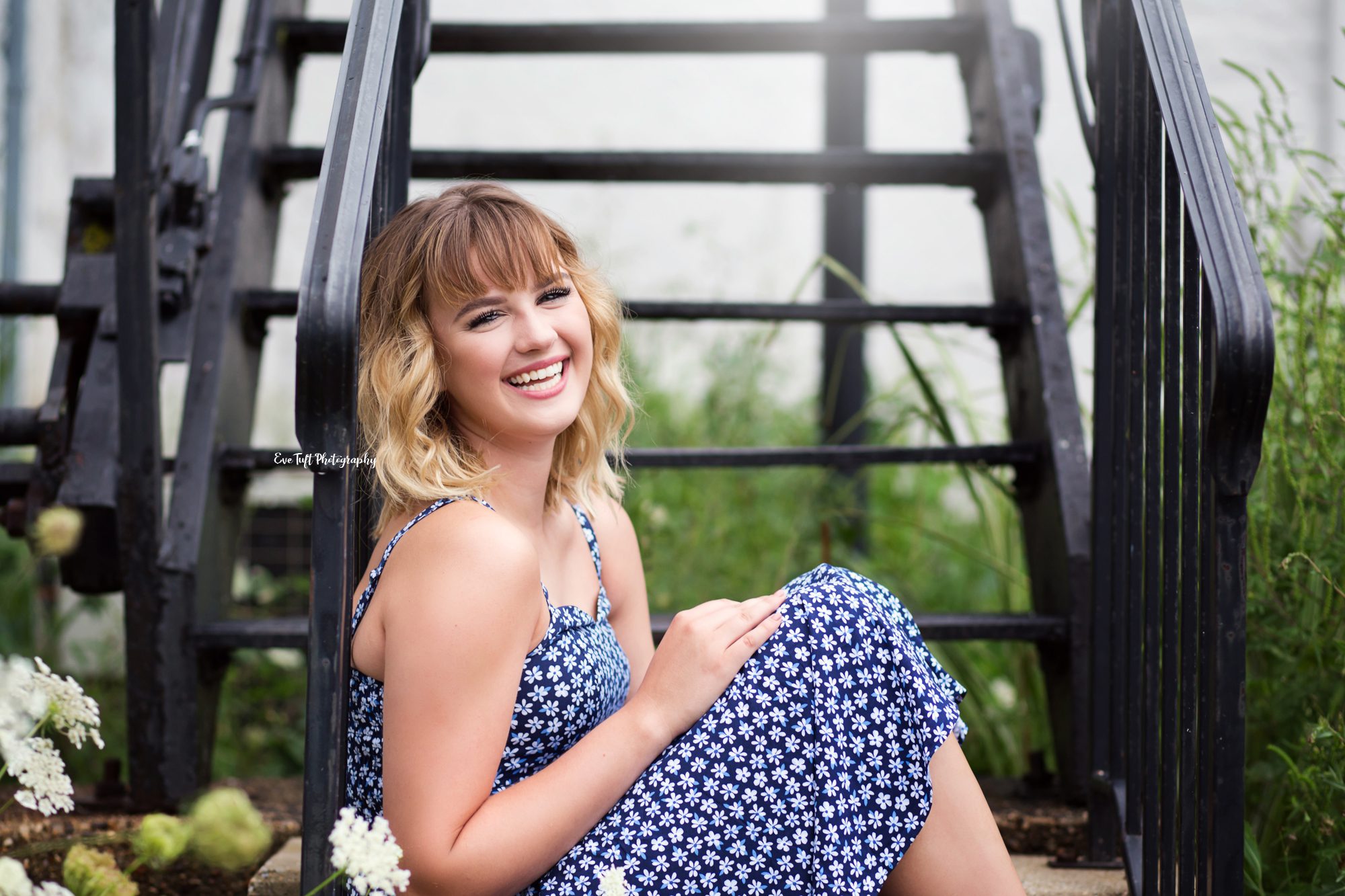 Senior girl sitting on black stairs and laughing | Senior Photographer