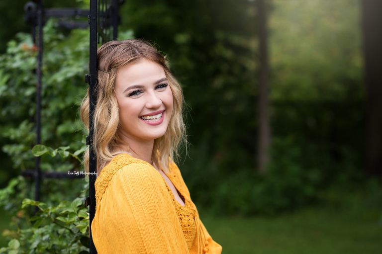 Dow High Senior girl smiling for the camera in a rose garden in Midland, Michigan | High School Photographer in Michigan