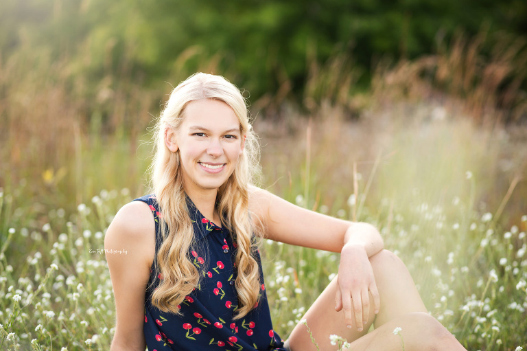 Beautiful senior girl sitting in some wildflowers at the CNC | Outdoor senior photographer in Michigan
