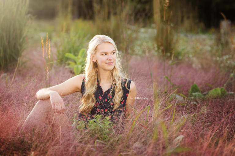 Teenage girl sitting in purple flowers outside in a field | Senior Photographer in Michigan