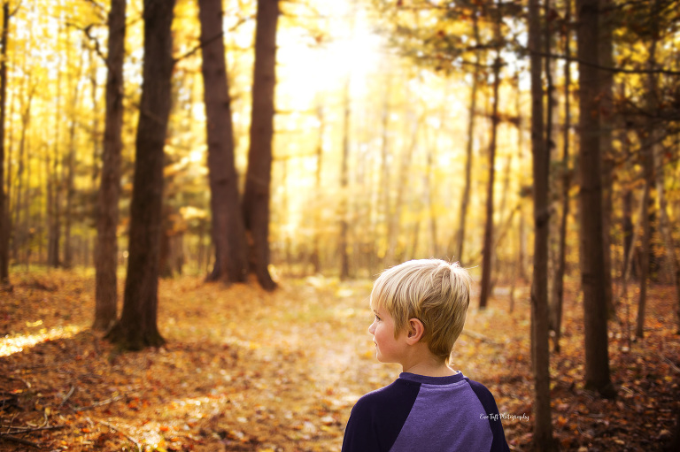 A boy gazes out over a wooded forest on that one week of fall in Midland, Michigan | Senior Photographer