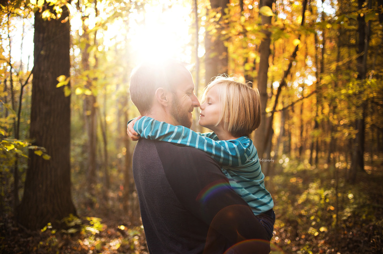 A father holds his daughter close outside in the forest on that one day in fall | Michigan's senior photographer