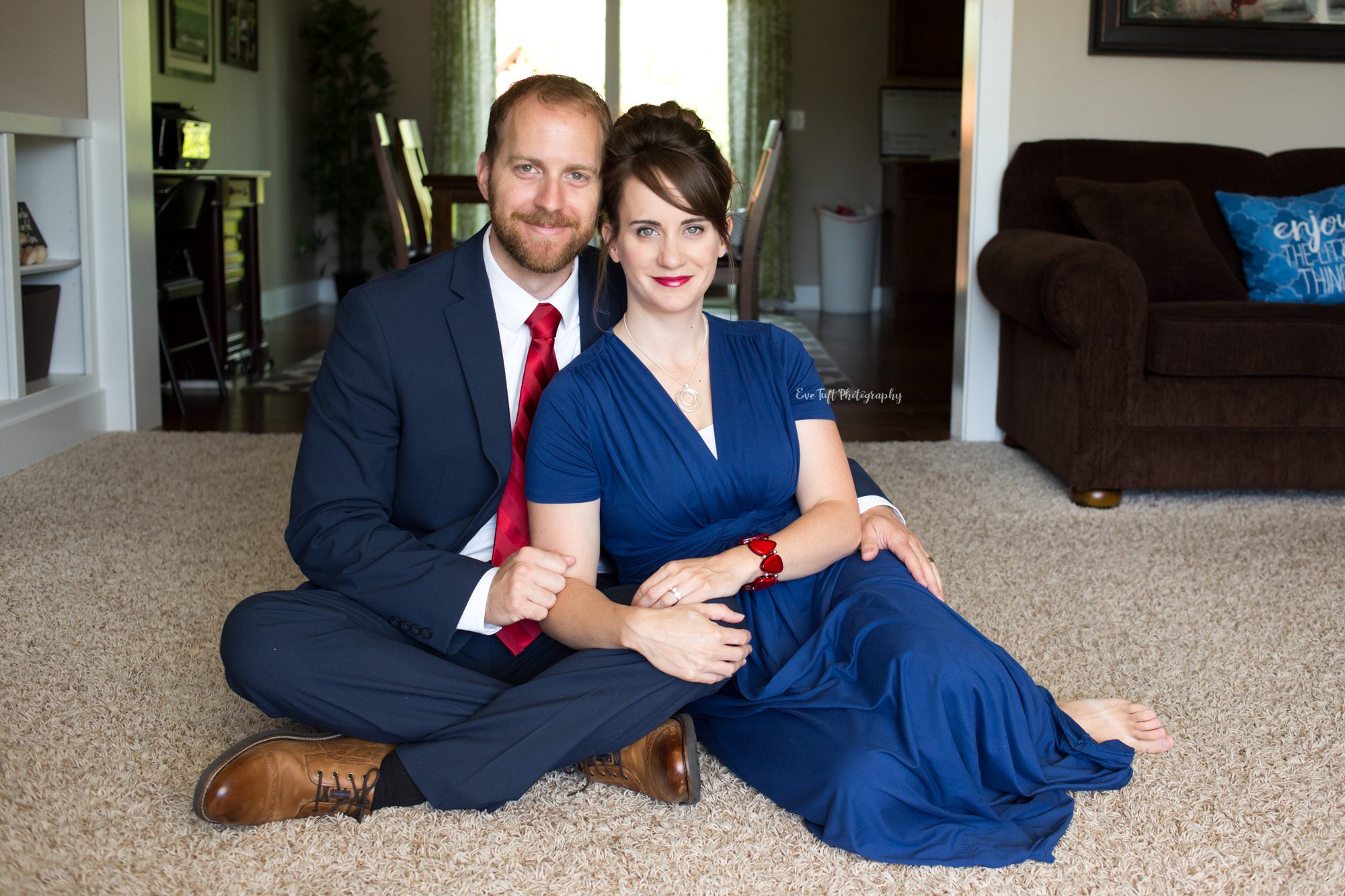 A woman and her husband pose in the living room wearing nice clothes | Senior Photographer in Midland, MI