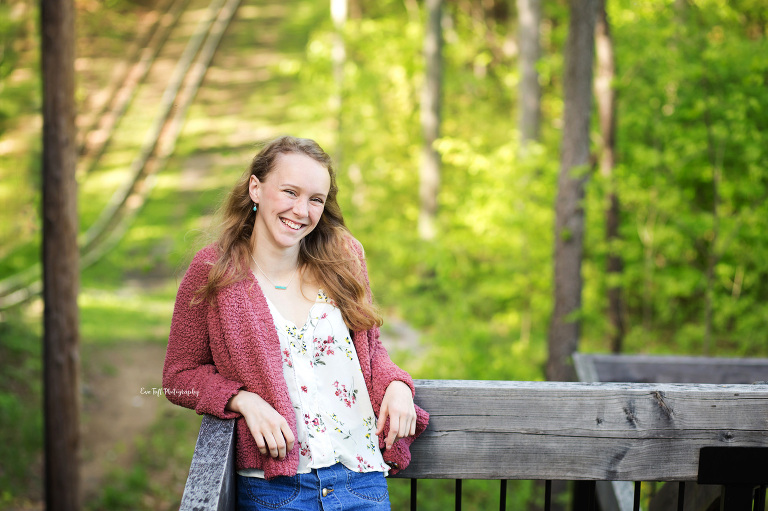 Senior girl leaning against a wooden staircase outside at City Forest | Why I Love My Job of being a senior photographer in Midland, Michigan