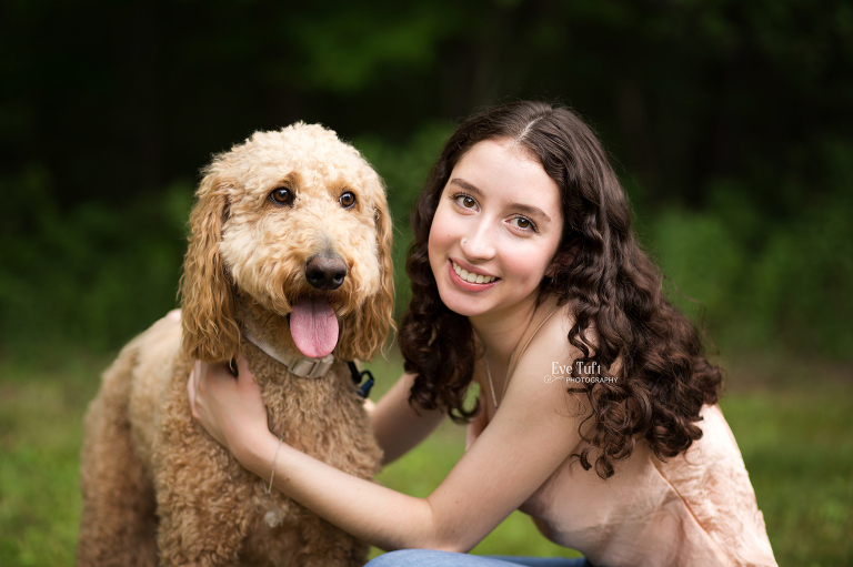 A senior girl crouches down next to her dog for their outdoor pictures | Michigan Photographer in Midland