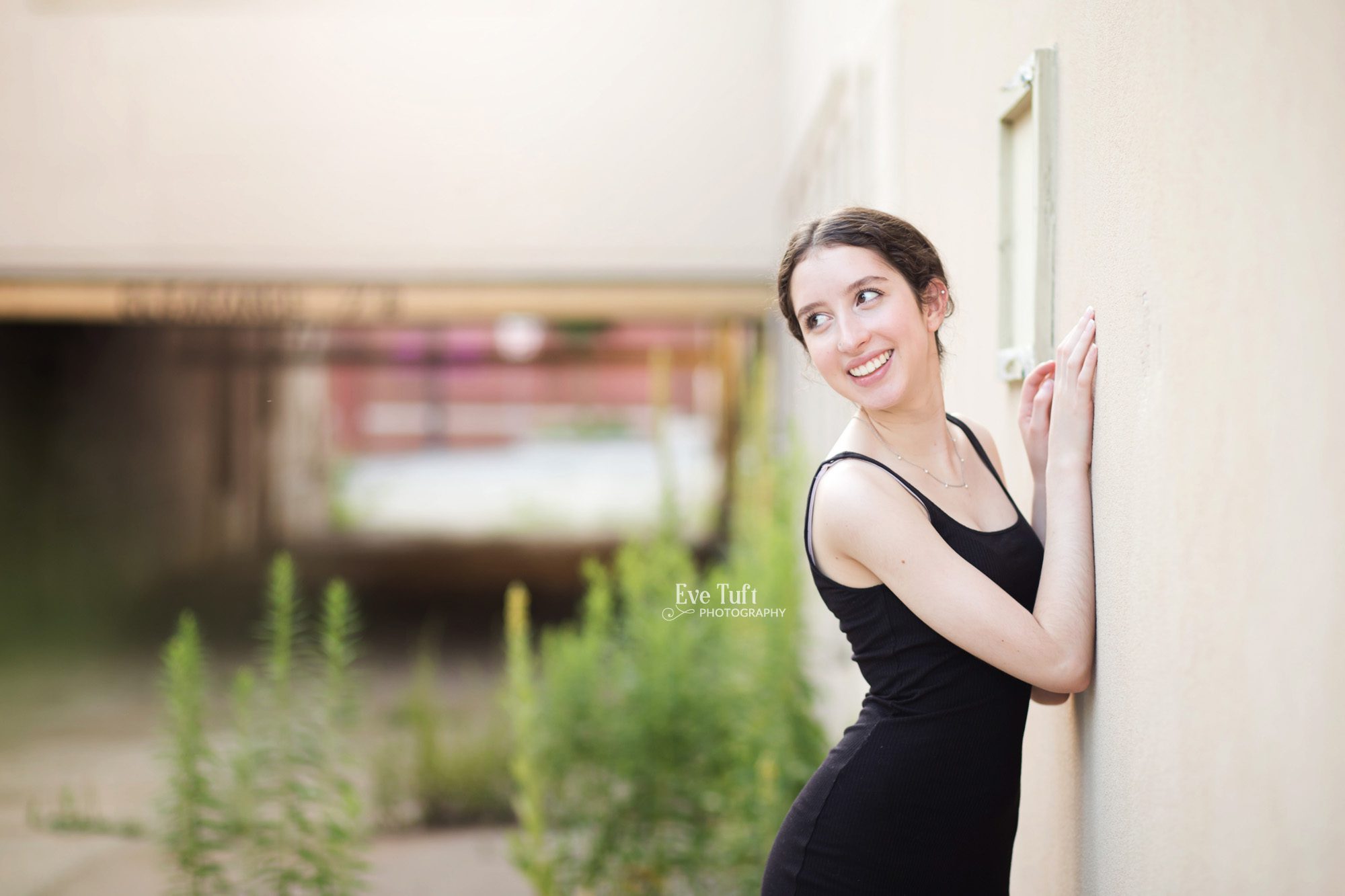 A senior leans against a wall in an alley in Downtown Midland, Michigan