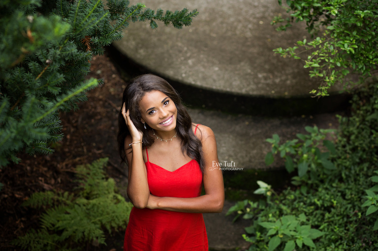 A senior girl looks up while on some stairs at Dow Gardens outside | New Locations for a senior photographer in Michigan